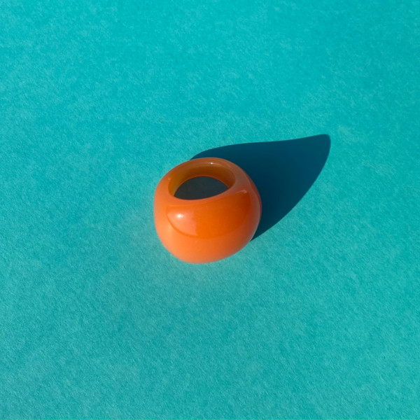 Becky orange ring i akryl paa turkis baggrund