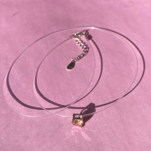 Marbel halskaede med champagne zirkon i soelvindfatning på 'usynlig' kaede paa rosa baggrund