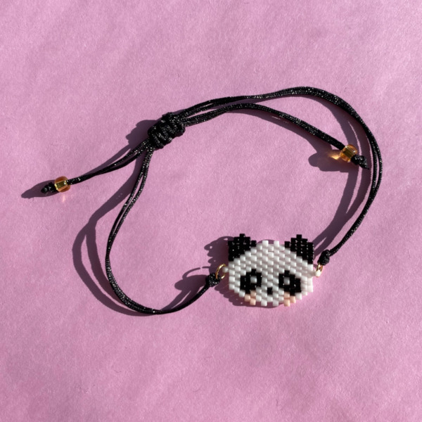 Mindy armbaand af sort traad med panda ansigt lavet i perler paa rosa baggrund