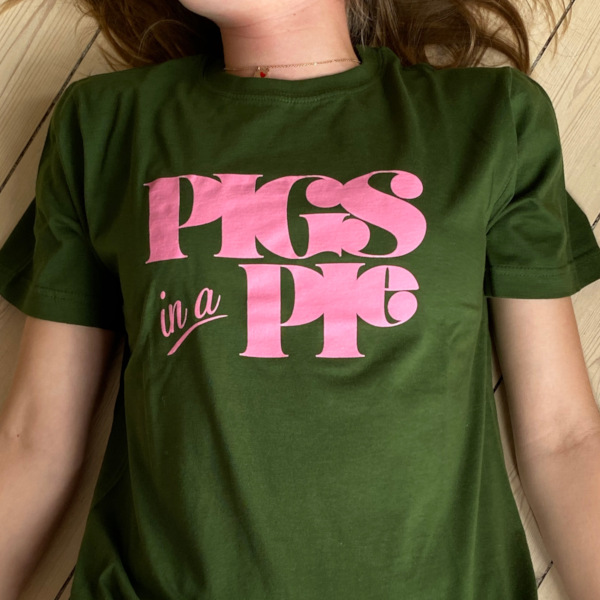 Groen t-shirt med Pigs in a Pie tryk paa liggende model