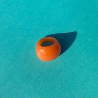 Becky orange ring i akryl paa turkis baggrund